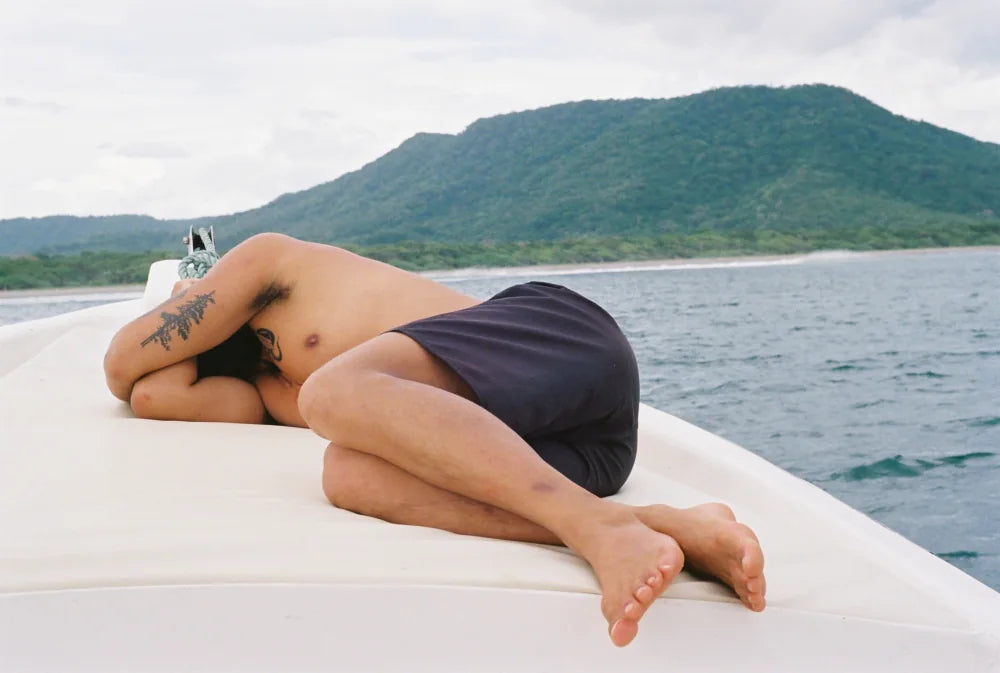 Van asleep on the bow of a boat while the surf breaks behind